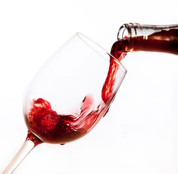 Red wine pouring into glass, isolated on white background