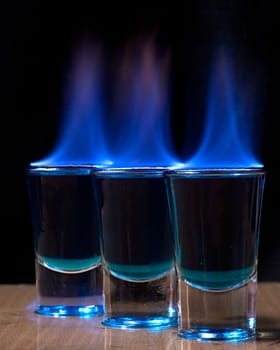 Burning drink in shot glass on a table