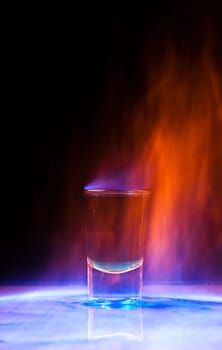 Burning drink in shot glass on a table