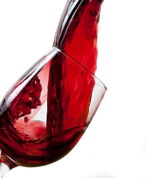 Red wine pouring into glass, isolated on white background