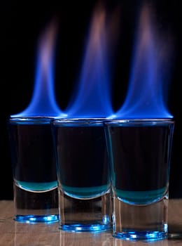 Burning drink in shot glass on a table