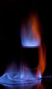 Burning drink in shot glass on a table