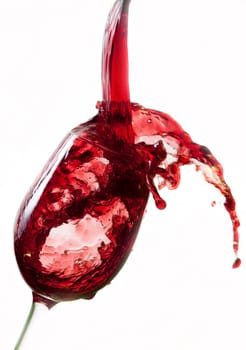 Red wine pouring into glass, isolated on white background