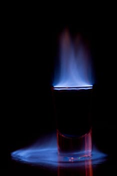 Burning drink in shot glass on a table