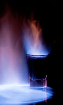 Burning drink in shot glass on a table