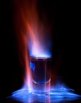 Burning drink in shot glass on a table