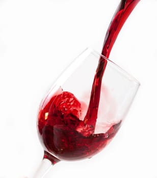 Red wine pouring into glass, isolated on white background