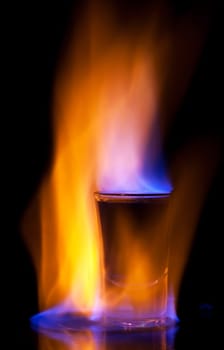 Burning drink in shot glass on a table
