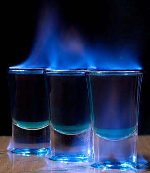 Burning drink in shot glass on a table