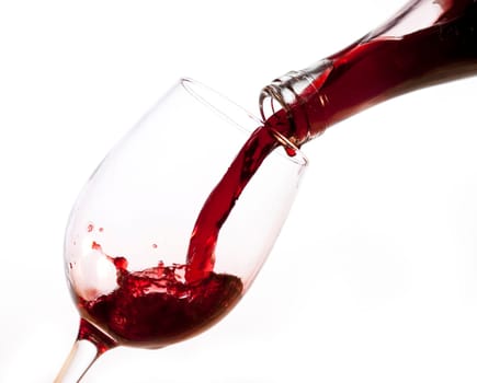 Red wine pouring into glass, isolated on white background