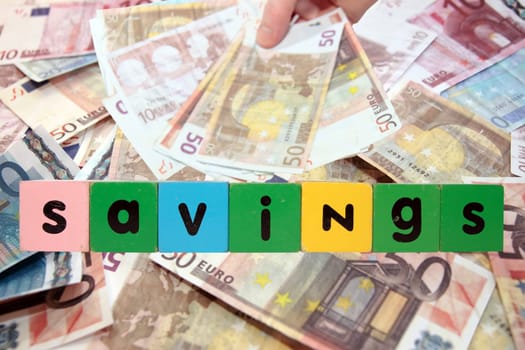 toy letters that savings against a money background with clipping path