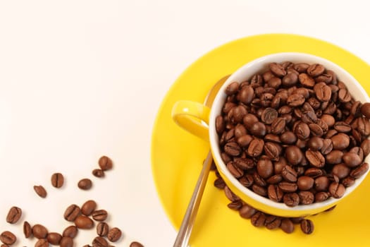 Yellow coffee cup with espresso beans