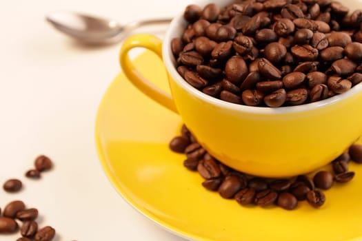 Yellow coffee cup with espresso beans
