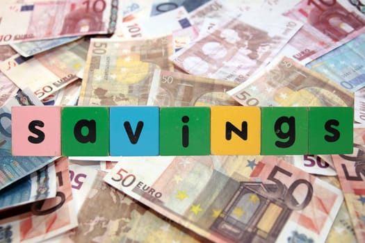 toy letters that savings against a money background with clipping path