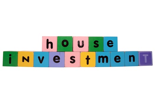 toy letters that spell house investment against a white background with clipping path