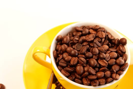 Yellow coffee cup with espresso beans