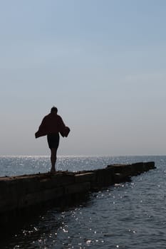 lonely boy go over the pier into the sea