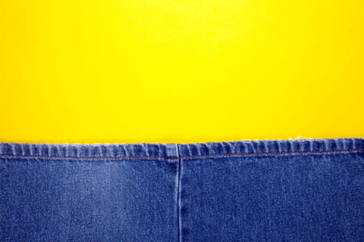 Blue jeans with yellow stitches and yellow background
