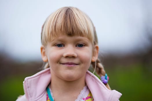 Portrait of a cute little girl outdoors on a spring day