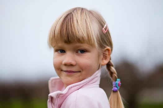 Portrait of a cute little girl outdoors on a spring day