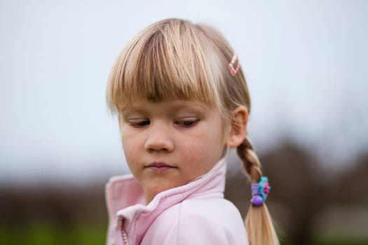 Portrait of a cute little girl outdoors on a spring day