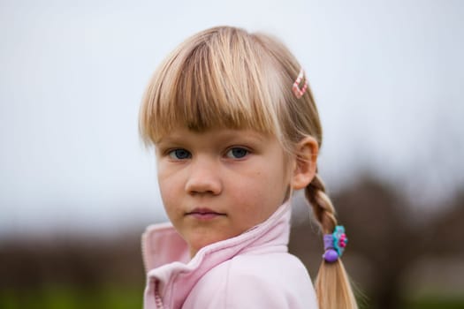 Portrait of a cute little girl outdoors on a spring day