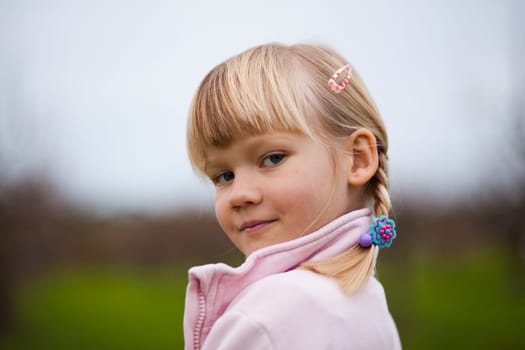 Portrait of a cute little girl outdoors on a spring day