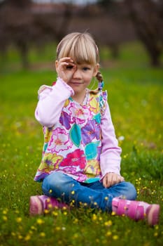 Cute little girl outdoors looking through imaginary binoculars
