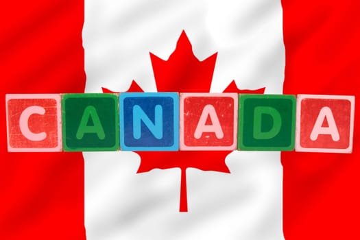toy letters that spell canada against a flag background with clipping path