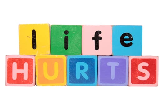toy letters that spell life hurts against a white background with clipping path