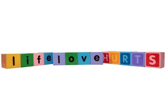 toy letters that spell life love hurts against a white background with clipping path