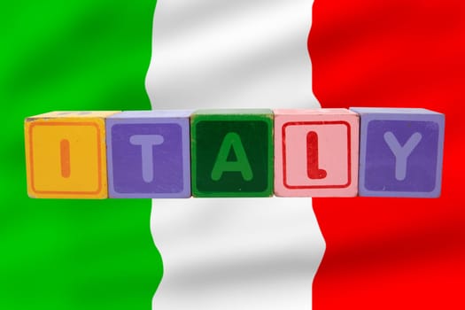 toy letters that spell italy against a flag background with clipping path