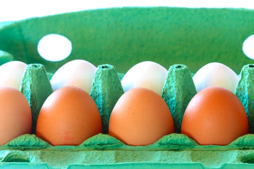 Brown and white chicken eggs in a carton