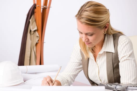 Female architect attractive working on a blueprint sketches in office