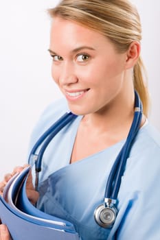 Attractive female doctor standing with stethoscope and folders isolated portrait