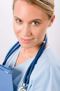 Attractive female doctor standing with stethoscope and folders isolated portrait