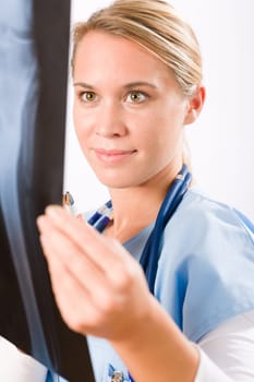 Young female doctor examining x-ray isolated on white background