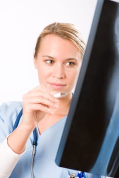 Young female doctor examining x-ray isolated on white background