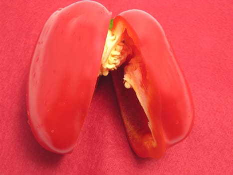 Red bell pepper halved on red placemat