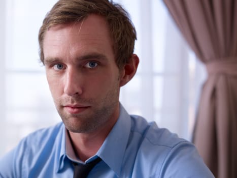 Portrait of mid adult pensive caucasian businessman in hotel room
