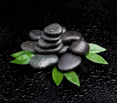 zen stones and leaves with water drops. leaf and basalt stones.