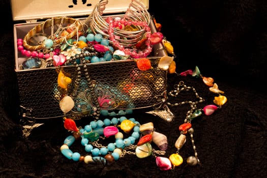 A silver case spilling brightly colored trinkets