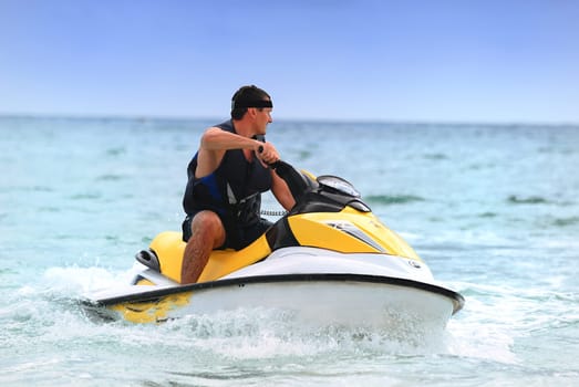 Man on Wave Runner turns fast on the water