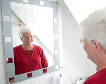 Cheerful pensioner looking in the mirror