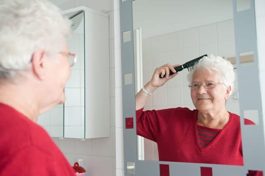 Senior woman combing her hair