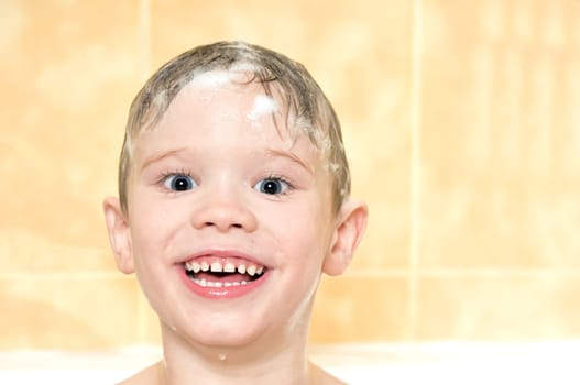 child washing in the shower with a foam on the head
