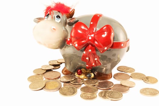 Coin box-cow and the scattered coins on a white background
