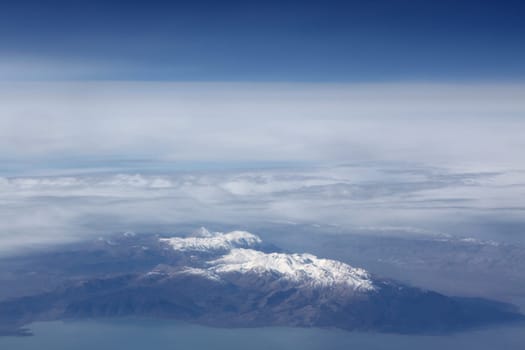 View from a plane window on snow-covered mountains
