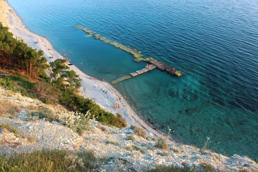 The top view on a wild beach and the azure sea