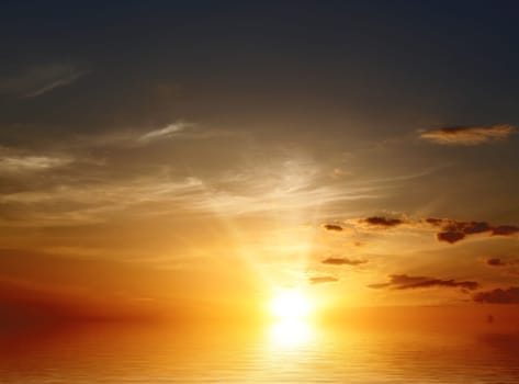 The beautiful cloudy sky during a sunset and reflection in water
